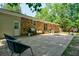 Brick home's paved patio with modern outdoor furniture, a grill, and access to lush green backyard at 7 Azalea Ct, Goose Creek, SC 29445