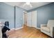 Cozy bedroom with light blue walls, hardwood floors, a ceiling fan, and a comfortable armchair near the closet at 7 Azalea Ct, Goose Creek, SC 29445