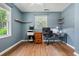 Bright bedroom features light blue walls, hardwood floors, and a functional workstation with floating corner shelves at 7 Azalea Ct, Goose Creek, SC 29445
