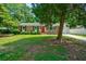 Charming brick home featuring a red door, front porch, green lawn, and driveway at 7 Azalea Ct, Goose Creek, SC 29445
