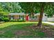 Charming brick home with a red door, lush green lawn, and mature trees at 7 Azalea Ct, Goose Creek, SC 29445