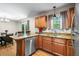 Open kitchen view, with stainless steel dishwasher, wooden cabinetry, and an adjacent dining area at 7 Azalea Ct, Goose Creek, SC 29445