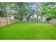Large backyard with a well-maintained lawn, mature trees, a wooden fence, and a trampoline, ideal for outdoor activities at 709 Black Oak Blvd, Summerville, SC 29485