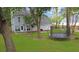 Well-kept backyard featuring green grass, a trampoline, tree swing, and a view of the house's exterior at 709 Black Oak Blvd, Summerville, SC 29485
