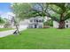 Traditional two-story home with an expansive green lawn, mature trees, and a basketball hoop on driveway at 709 Black Oak Blvd, Summerville, SC 29485