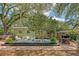 Lush backyard with mature trees, multiple seating areas, a patio, and a dining area at 735 Woodward Rd, Charleston, SC 29407