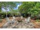 Relaxing backyard features fire pit, Adirondack chairs and is surrounded by beautiful trees and plants at 735 Woodward Rd, Charleston, SC 29407