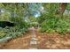 Scenic backyard view with stepping stone path, bench, and outdoor seating area at 735 Woodward Rd, Charleston, SC 29407