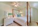 Cozy bedroom with four poster bed, ceiling fan, and white shuttered windows at 735 Woodward Rd, Charleston, SC 29407