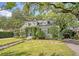 Charming green home with lush landscaping and mature trees providing ample shade at 735 Woodward Rd, Charleston, SC 29407
