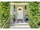 Close-up of the front door with classic lanterns, plants, and a stylish black and white tiled porch at 735 Woodward Rd, Charleston, SC 29407