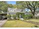 Inviting home featuring a lush front lawn, manicured shrubbery, and a cozy, vine-covered entryway at 735 Woodward Rd, Charleston, SC 29407