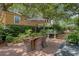Backyard view of an outdoor dining table on a brick patio and lush landscaping at 735 Woodward Rd, Charleston, SC 29407