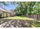 Expansive backyard with lush greenery, mature trees, deck, patio and privacy fence at 8166 Scottswood Dr, North Charleston, SC 29418