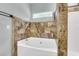 Luxurious bathtub with decorative tile, next to a shower and a window letting the sunshine in at 8166 Scottswood Dr, North Charleston, SC 29418