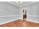 Empty dining room showcasing hardwood floors, a chandelier, neutral paint, and connecting doorway to the kitchen at 8166 Scottswood Dr, North Charleston, SC 29418