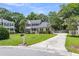 Suburban home with lush lawn, mature landscaping, and a long driveway at 8166 Scottswood Dr, North Charleston, SC 29418