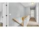 Hallway with neutral walls, carpet, white trim and natural wood banister leading to other rooms at 8166 Scottswood Dr, North Charleston, SC 29418