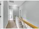 Hallway with neutral walls, carpet, white trim and natural wood banister leading to other rooms and a bathroom at 8166 Scottswood Dr, North Charleston, SC 29418
