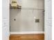 Empty Laundry room featuring hardwood floors, utility sink hookups, and wire rack shelving at 8166 Scottswood Dr, North Charleston, SC 29418