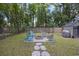 Landscaped backyard with a brick fire pit, chairs, a grilling station, and a storage shed at 825 Savage Rd, Charleston, SC 29414