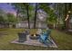 Charming backyard with a fire pit, Adirondack chairs, and well-maintained lawn offers an ideal spot for outdoor relaxation at 825 Savage Rd, Charleston, SC 29414