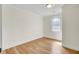 Neutral bedroom boasts hardwood floors, white trim, and a sunny window at 8612 Delhi Rd, North Charleston, SC 29406