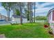 Spacious backyard featuring a well-kept lawn, tall trees, and a white picket fence at 8965 N Red Maple Cir, Summerville, SC 29485