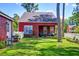 Charming backyard with well-maintained lawn, mature trees, red siding and a white picket fence at 8965 N Red Maple Cir, Summerville, SC 29485