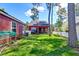 Expansive backyard with lush green lawn, white picket fence, and exterior view of red home at 8965 N Red Maple Cir, Summerville, SC 29485