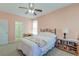 Comfortable bedroom featuring light pink walls, a ceiling fan, a window with white curtains, and a queen size bed at 8965 N Red Maple Cir, Summerville, SC 29485
