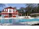 Community pool with red barn-style community center, pool-side shaded area, and ample space to relax at 8965 N Red Maple Cir, Summerville, SC 29485
