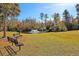 Scenic community pond with a fountain, benches, mature trees, and a grassy area, perfect for relaxation and enjoying nature at 8965 N Red Maple Cir, Summerville, SC 29485