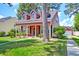 Charming two-story home with red siding, dormer windows, a front porch, and well-manicured landscaping at 8965 N Red Maple Cir, Summerville, SC 29485