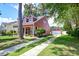 View of a charming red home, showcasing the driveway and a detached garage at 8965 N Red Maple Cir, Summerville, SC 29485