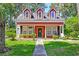 Charming two-story red home featuring a well-manicured lawn and inviting front porch at 8965 N Red Maple Cir, Summerville, SC 29485