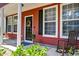 Inviting front porch with rocking chair and decorative wreath on the red front door at 8965 N Red Maple Cir, Summerville, SC 29485