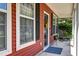Inviting front porch with decorative wreath on the door, rocking chair, and well-manicured landscaping at 8965 N Red Maple Cir, Summerville, SC 29485