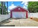 Detached garage with white door and red siding, located beside a white picket fence and driveway at 8965 N Red Maple Cir, Summerville, SC 29485