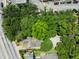 Overhead aerial view of home surrounded by lush trees, a gravel driveway, and neighboring properties at 9 Wesley Dr, Charleston, SC 29407