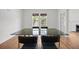 Bright dining room with a modern glass table, wooden floors, and natural light from the window at 9 Wesley Dr, Charleston, SC 29407