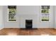 Classic brick fireplace with a black mantel, flanked by bright windows with wooded views at 9 Wesley Dr, Charleston, SC 29407