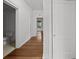 Hallway with hardwood floors leading to bathroom and other rooms, featuring traditional architectural details at 9 Wesley Dr, Charleston, SC 29407
