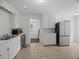Functional kitchen boasts white cabinetry, stainless steel appliances, and a neutral-tiled floor at 9 Wesley Dr, Charleston, SC 29407