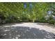 Spacious gravel parking area surrounded by lush greenery, offering ample space for vehicles and a touch of nature at 9 Wesley Dr, Charleston, SC 29407