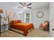 Stylish bedroom features a bed with an orange comforter, matching pillows, a ceiling fan, and a window at 101 Caleb Ct, Ladson, SC 29456