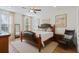 Bright bedroom featuring a leather-accented bed frame, wood floors, and abundant natural light from the large windows at 101 Caleb Ct, Ladson, SC 29456