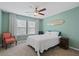 Bright bedroom with light-green walls, ceiling fan, large windows, and accent chair at 101 Caleb Ct, Ladson, SC 29456