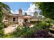 Charming back patio with brick exterior, a dining set with umbrella, and beautifully landscaped garden at 102 Ashborough Ave, Summerville, SC 29485