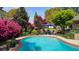 Scenic backyard featuring a pool, lounge area, lush greenery, colorful flowers, and ample patio space at 102 Ashborough Ave, Summerville, SC 29485